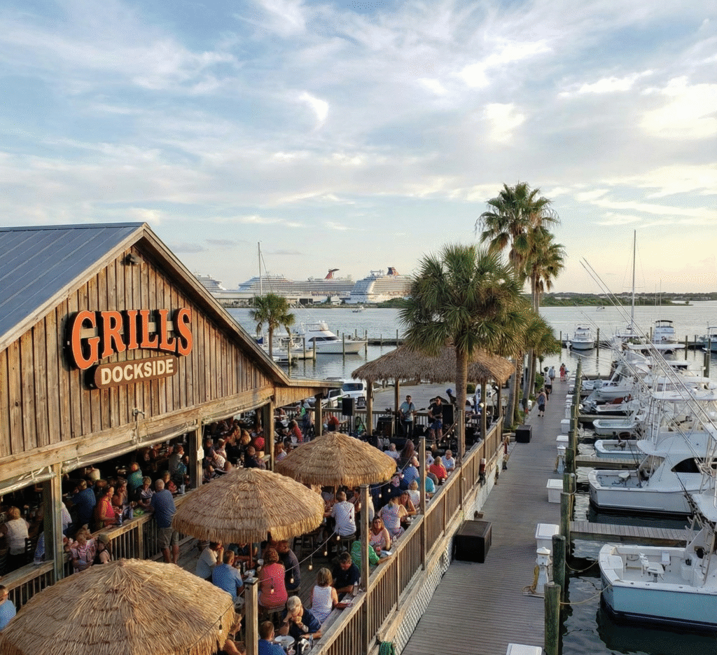 Visitors dine at Grills Dockside overlooking boats and cruise ships, a favorite local waterfront restaurant near homes for sale in Cape Canaveral.